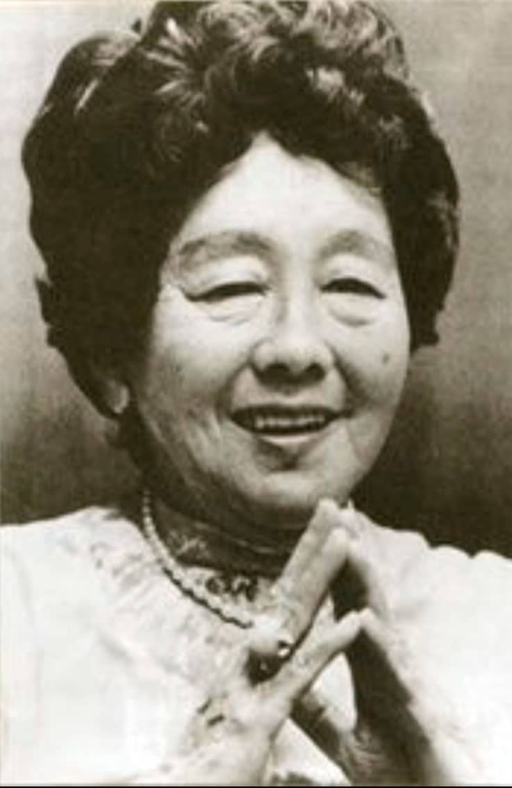 Photo of Hawayo Takata wearing a lace blouse with her fingertips touching