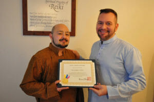 Christopher Tellez of San Francisco California receives his Reiki Master certificate from Brian Brunius of the NYC Reiki Center