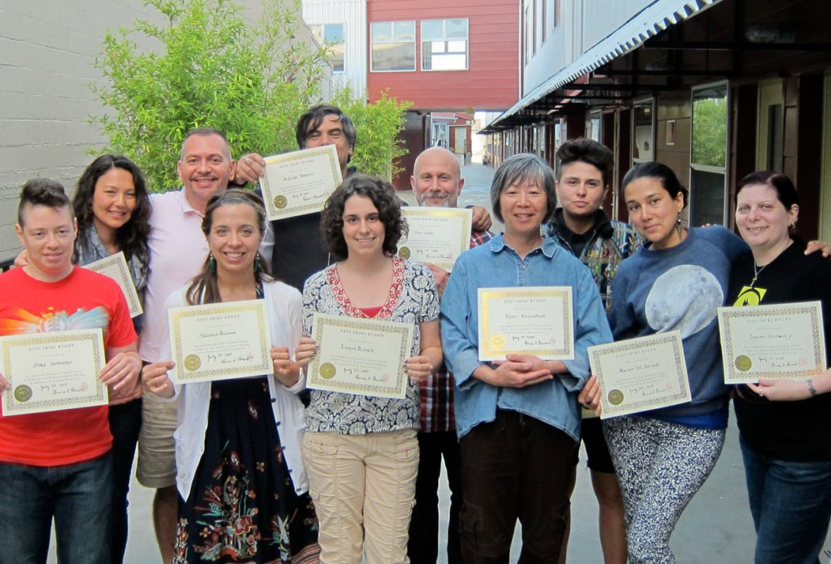 Reiki Master Brian Brunius with students holding their Reiki certificates at the completion of class.
