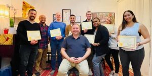 Photo of Reiki Master Brian Brunius of the NYC Reiki Center with Reiki students holding up their certificates at the end of the class.
