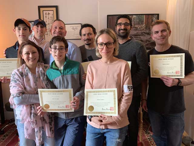 Photo of a Reiki Level 1 class at the NYC Reiki Center with students holding their Reiki Certificates