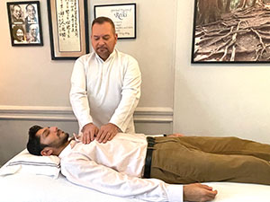 Photo of Brian Brunius giving a Reiki Treatment to a Client