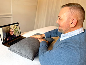 Photo of Brian Brunius talking on Zoom to a client and delivering a Virtual Reiki Treatment