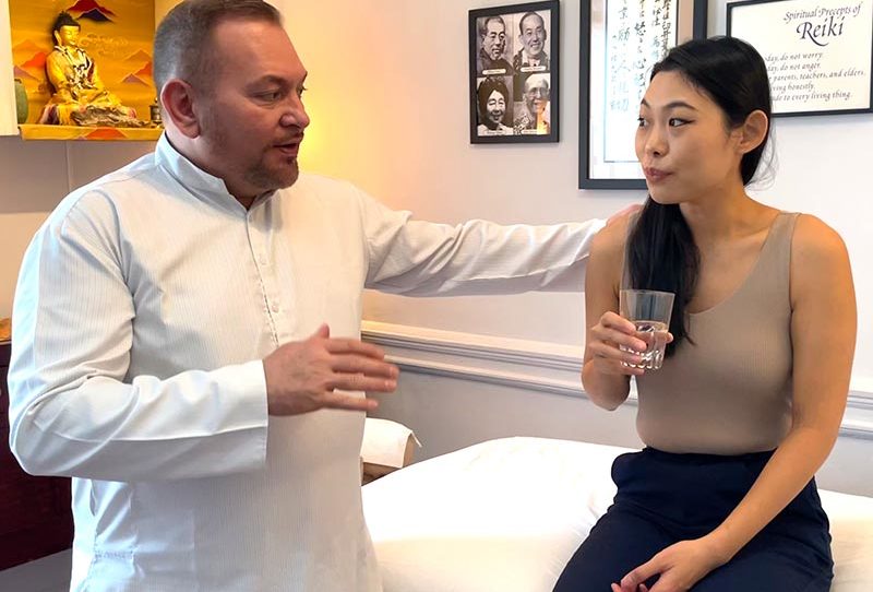 Reiki Master Brian Brunius talking with a Reiki client at the end of a treatment