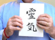 Photo of Brian Brunius holding a copy of Reiki: The Grey Book