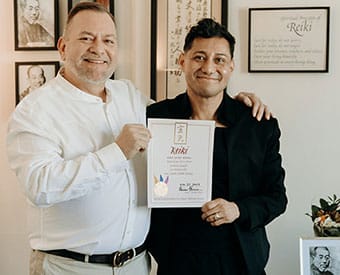Photo of Reiki Master Amilyo Escobar receiving his Master certificate from Brian Brunius in New York City on November 25, 2023.