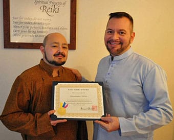 Christopher Tellez of San Francisco California receives his Reiki Master certificate from Brian Brunius of the NYC Reiki Center