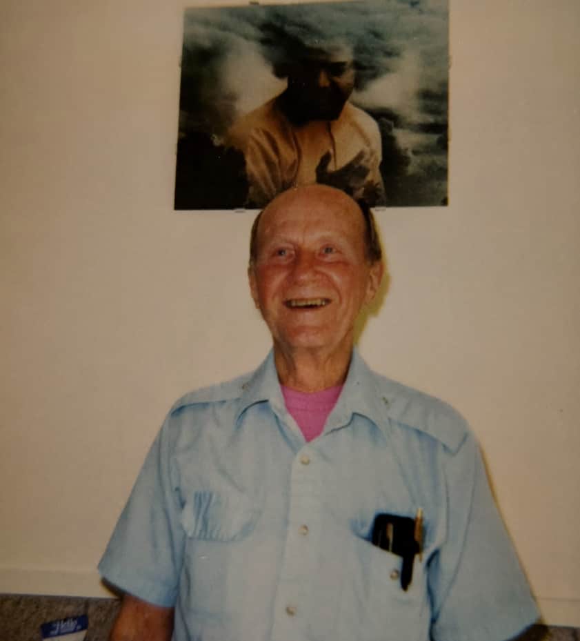 John-Gray-Sai-Baba Photo of Reiki Master John Harvey Gray standing under a photo of Sathya Sai Baba, the indian spiritual teacher